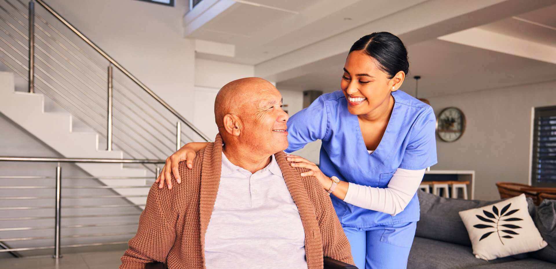 An older adult and a supportive companion sharing a warm moment at home
